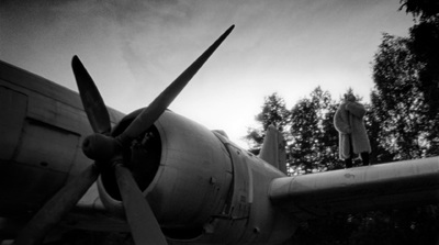 a black and white photo of a propeller plane