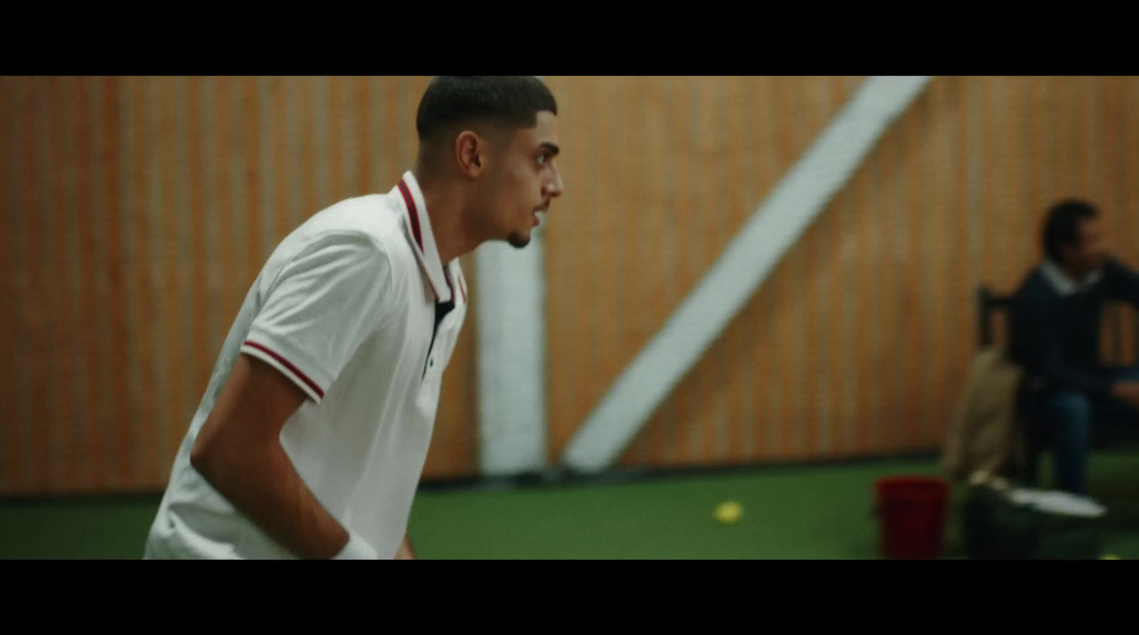 a man standing on a tennis court holding a racquet