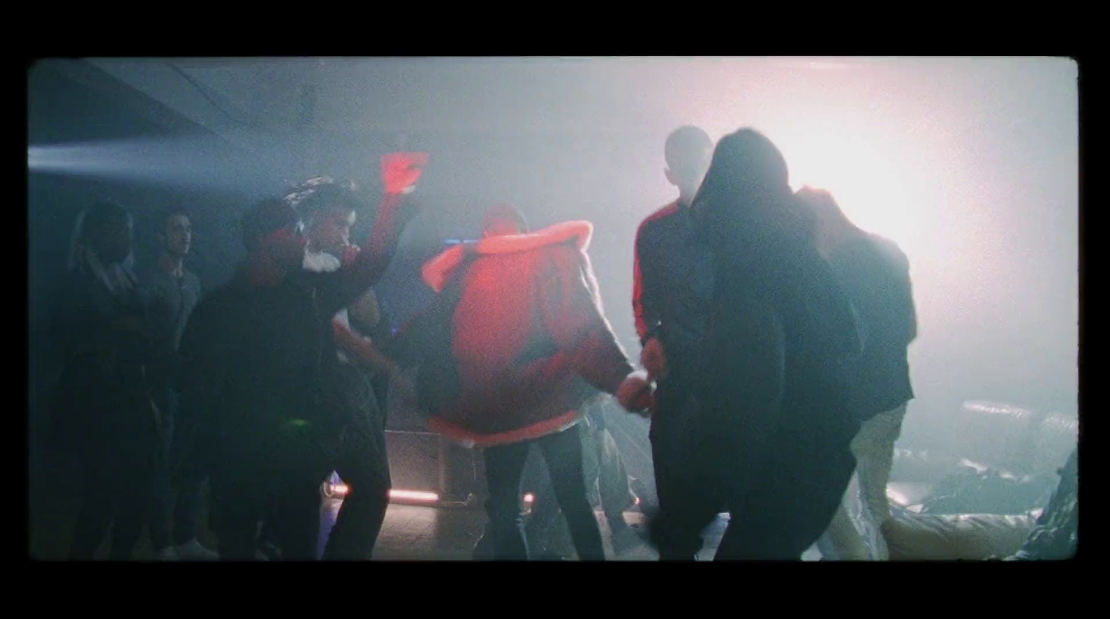 a group of people standing around in a dark room