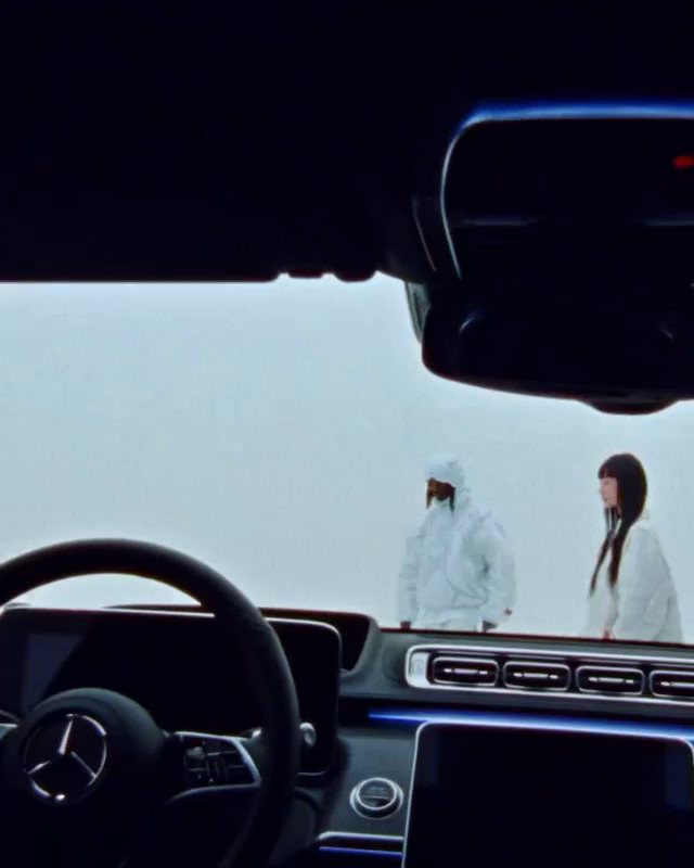 a car dashboard with two people in the background