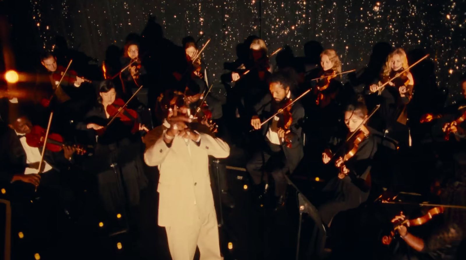 a man in a white suit is playing violin