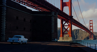 a car is parked in front of a bridge