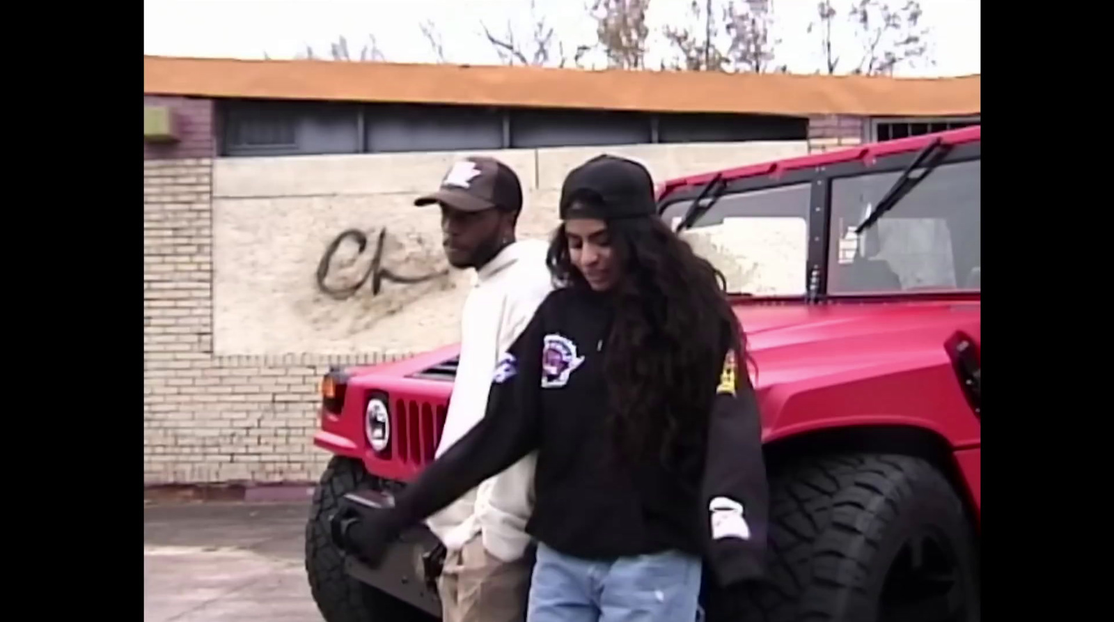 a man and a woman standing next to a red truck