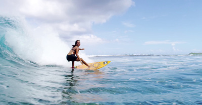 a woman riding a surfboard on a wave in the ocean