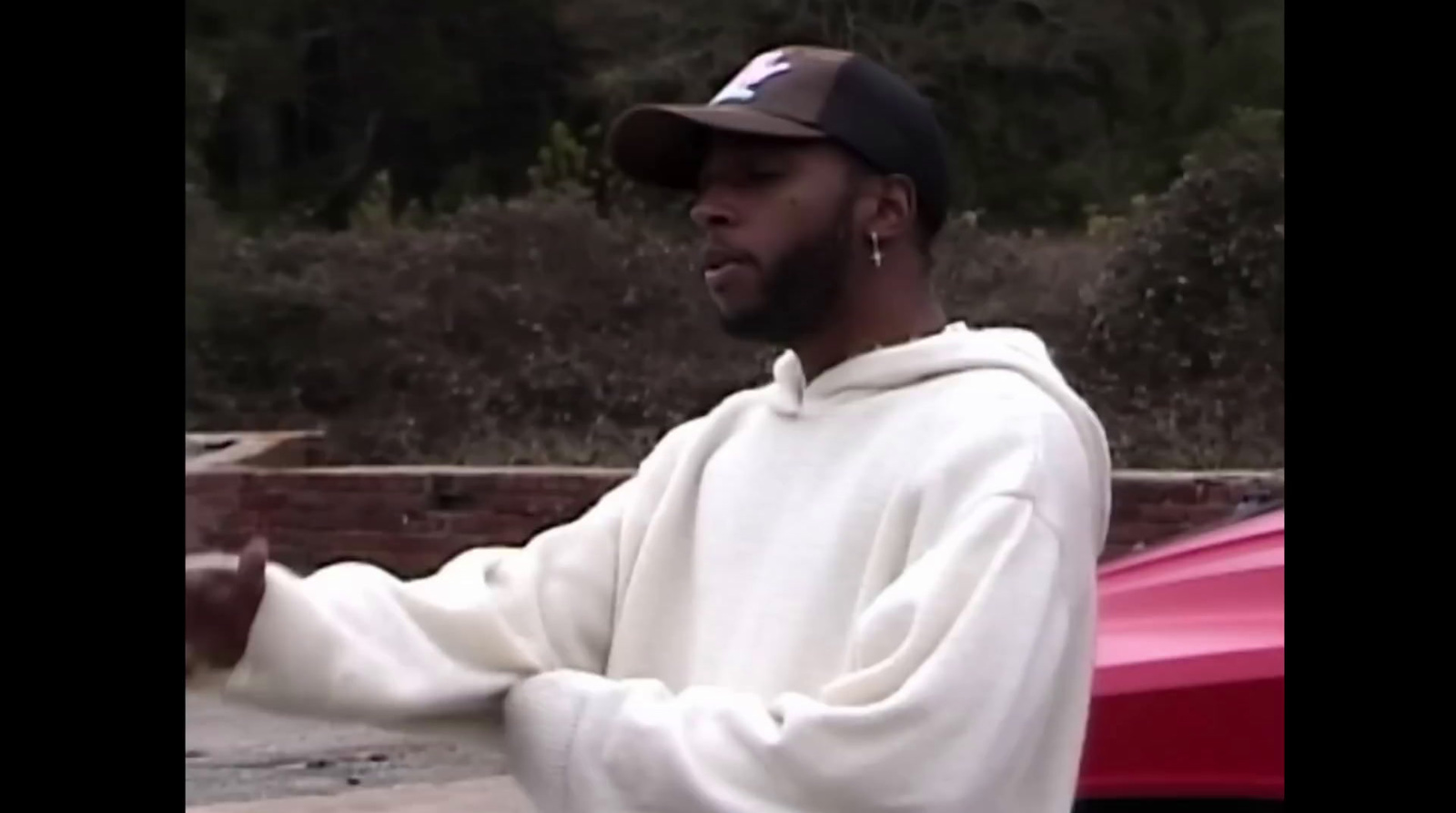 a black man in a white sweatshirt and a brown hat