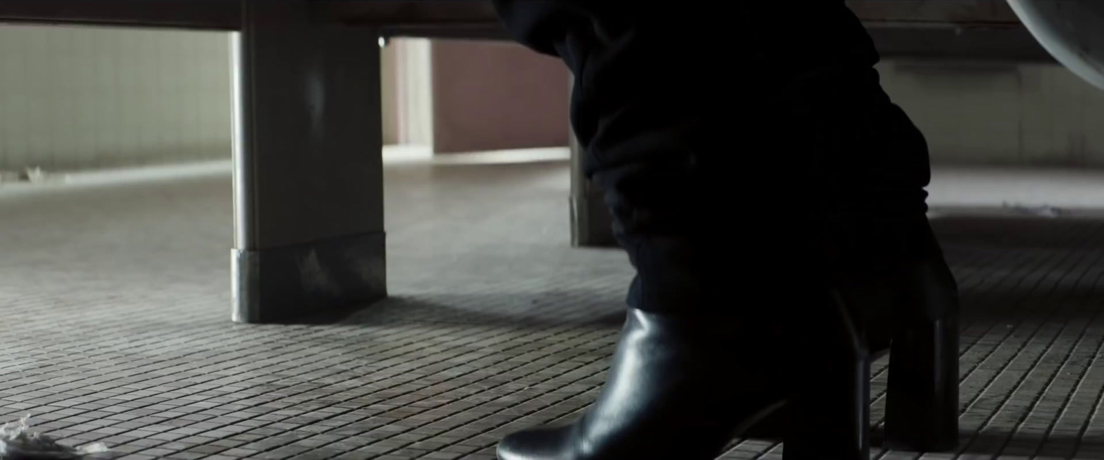 a person standing on a tiled floor next to a table