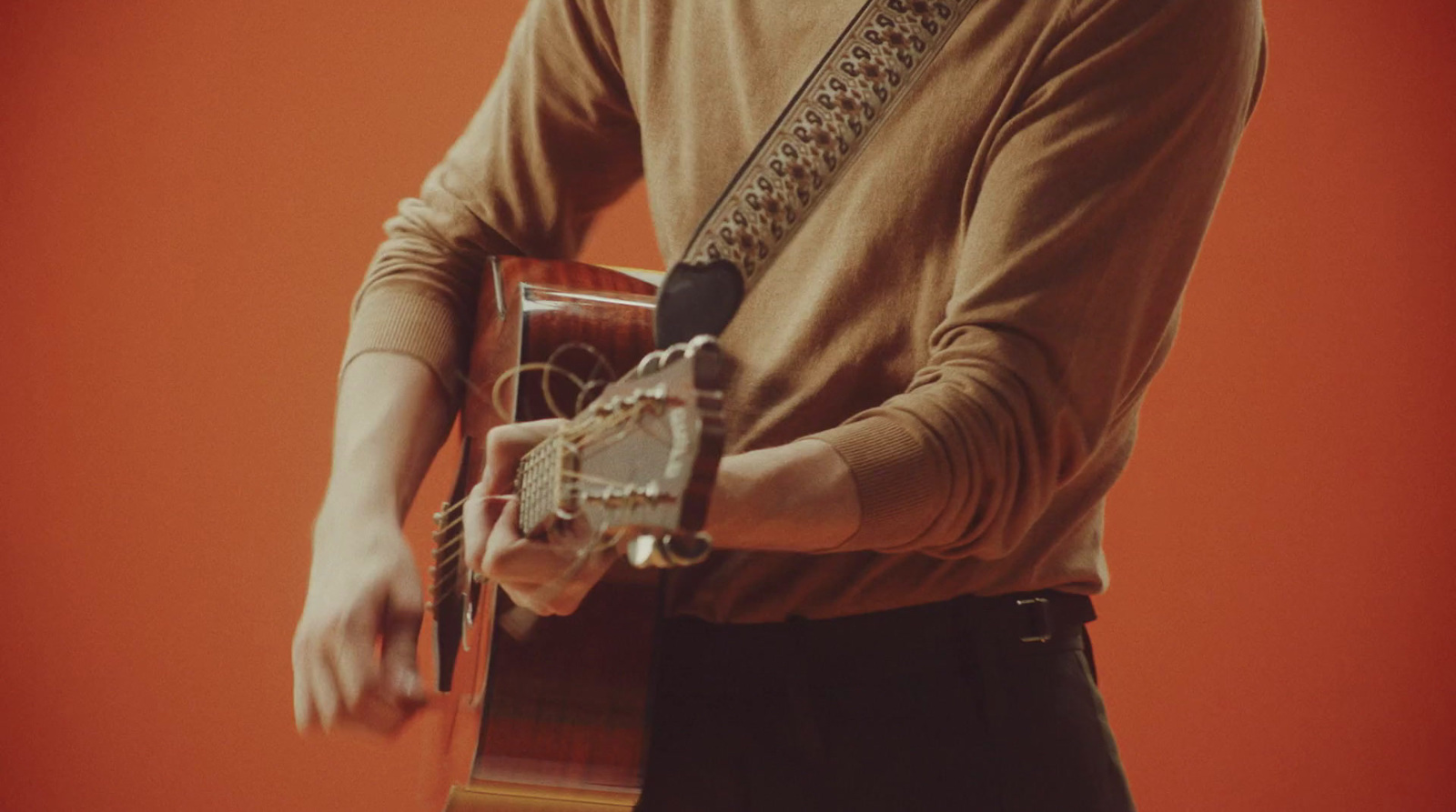 a man holding a guitar in his right hand