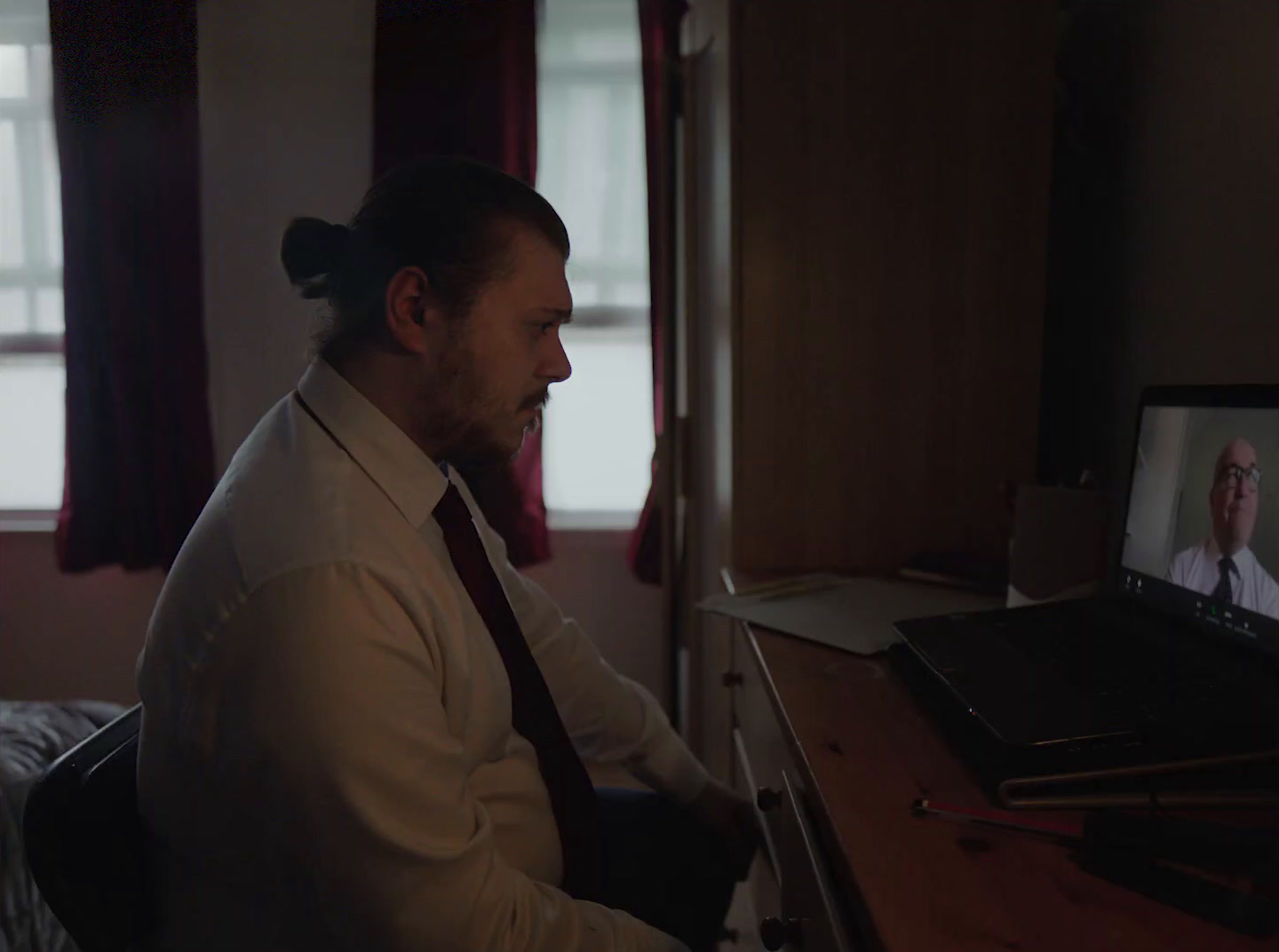 a man sitting at a desk in front of a laptop computer