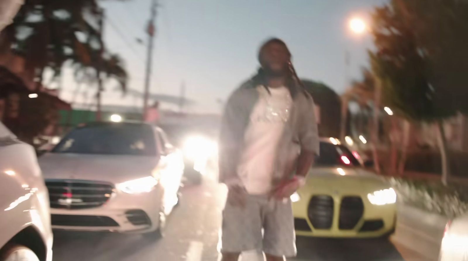 a man standing on the side of a road next to cars