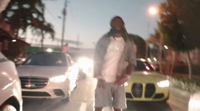 a man standing on the side of a road next to cars