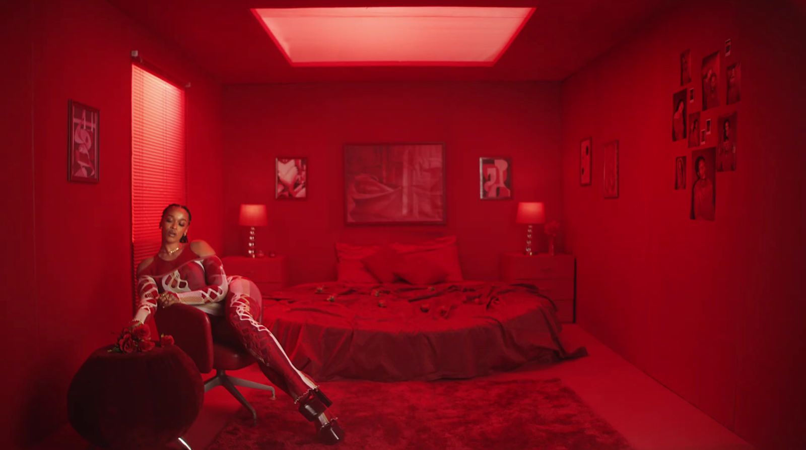 a woman sitting on a bed in a red room