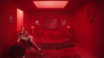 a woman sitting on a bed in a red room