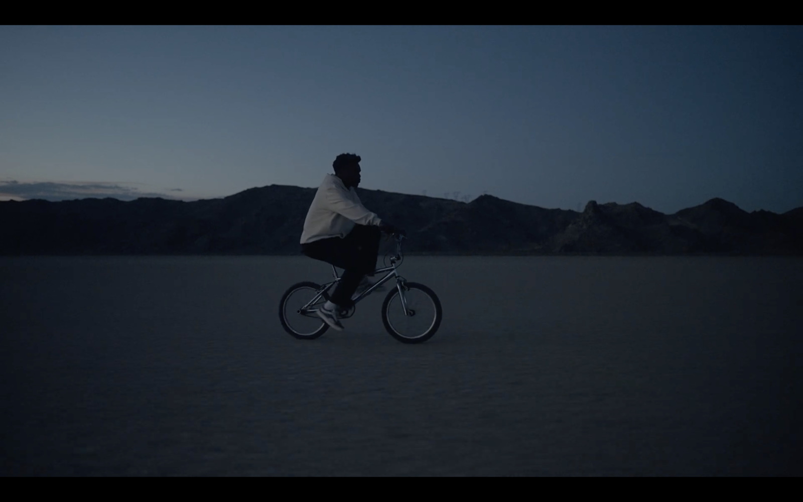 a man riding a bike in the middle of a desert