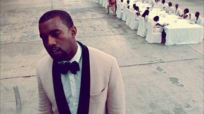 a man in a tuxedo standing in front of a long table