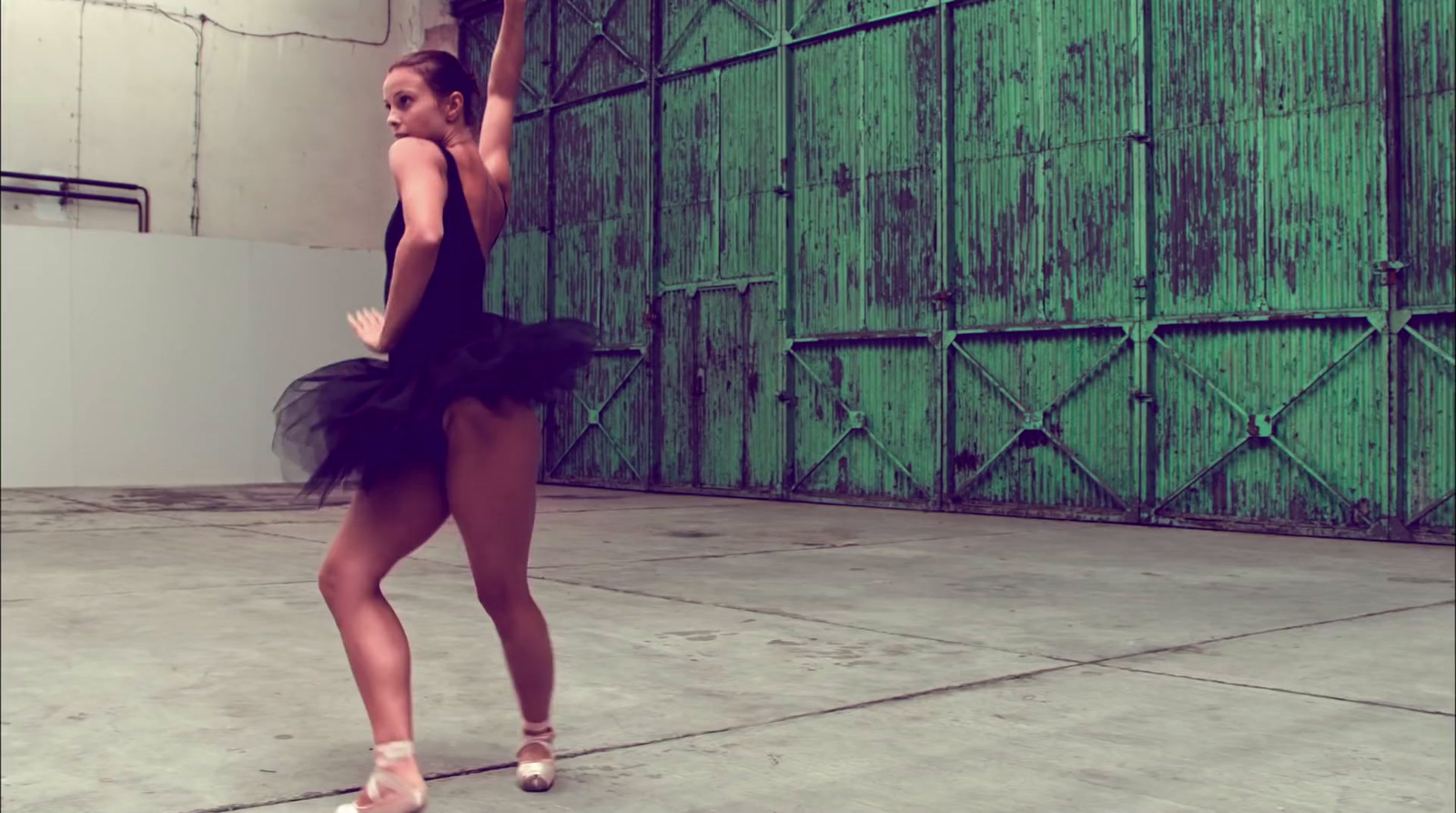 a woman in a black leotard is dancing