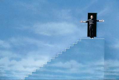 a man standing on top of a staircase with his arms outstretched