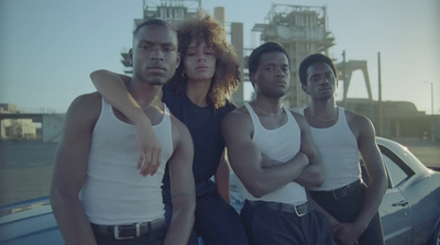 a group of men standing next to each other in front of a car