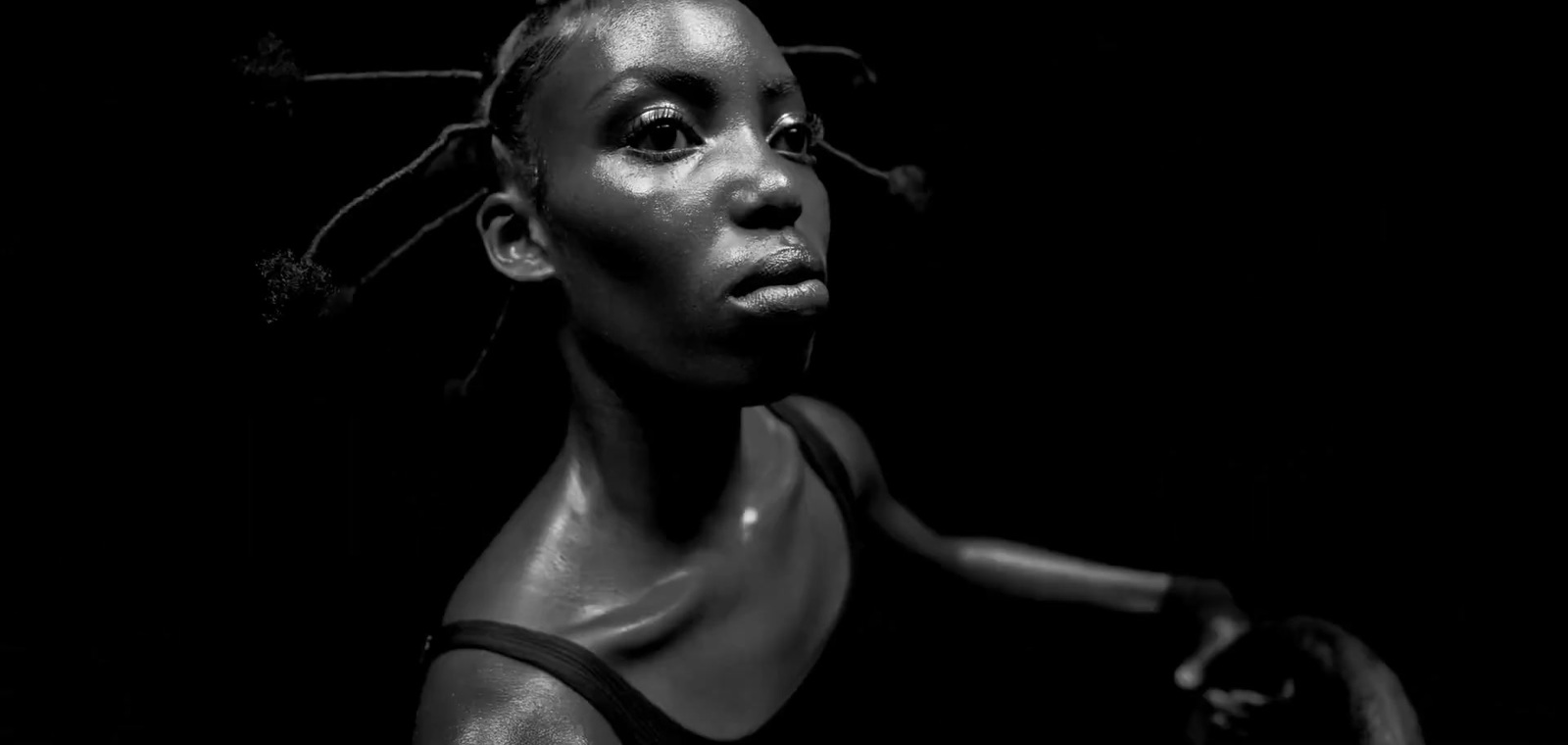 a black and white photo of a woman with dreadlocks