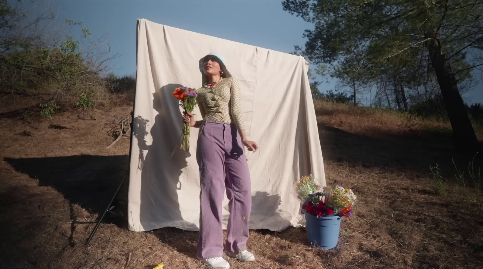 a woman standing in front of a white sheet