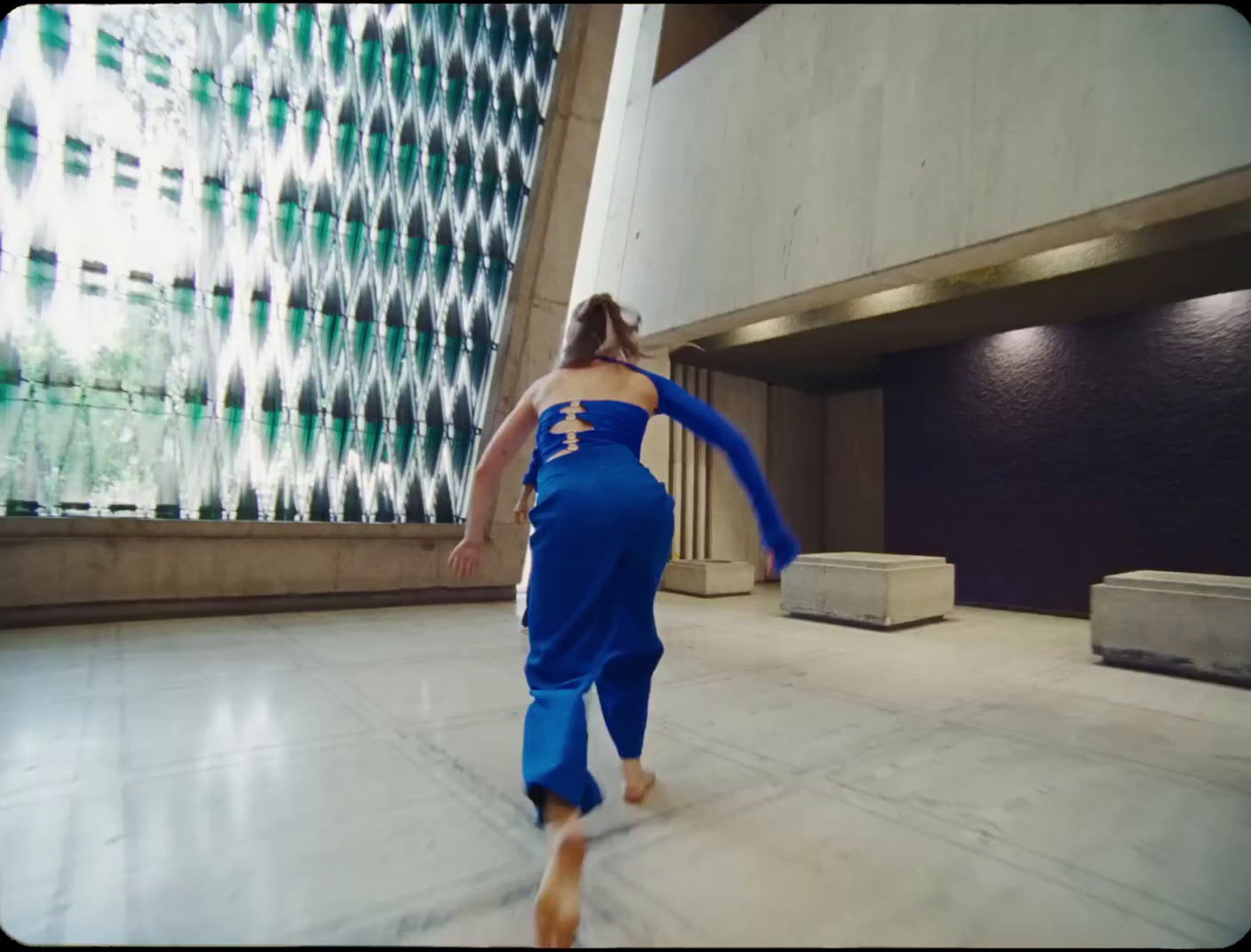 a woman in a blue jumpsuit is dancing