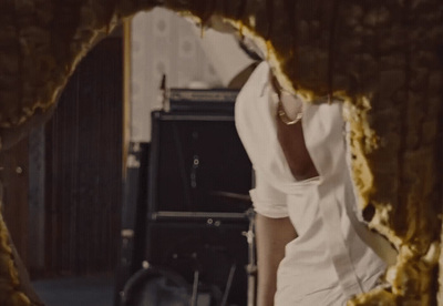 a woman standing in a room with a hole in the wall