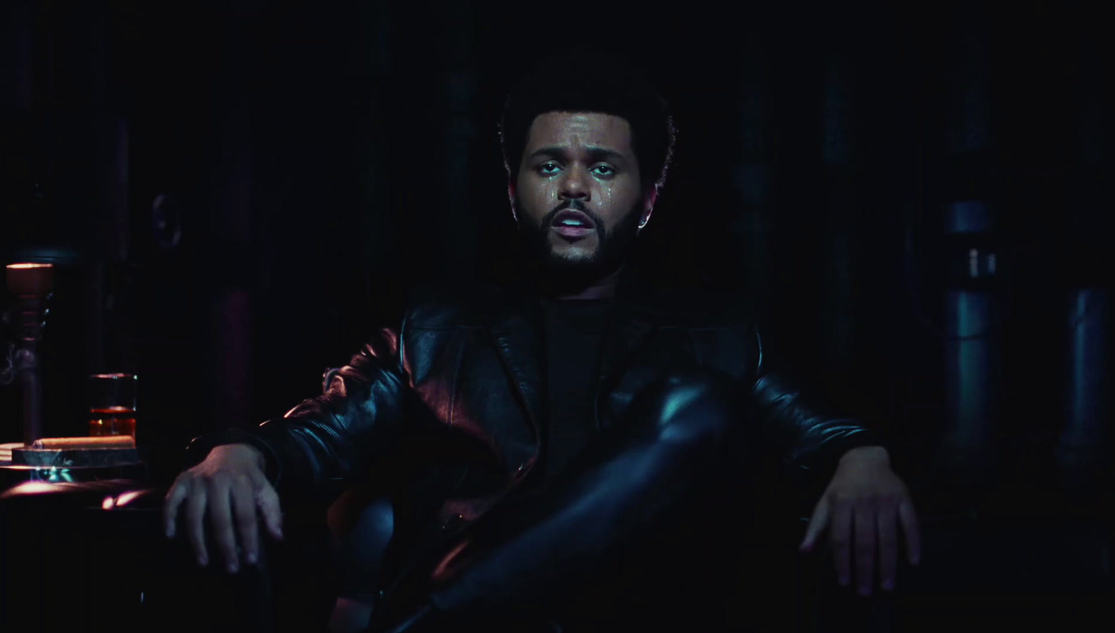 a man sitting in a chair in a dark room