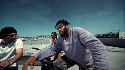 a man riding a bike next to another man on a skateboard