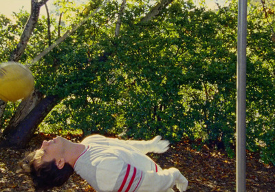 a man laying on the ground next to a street sign