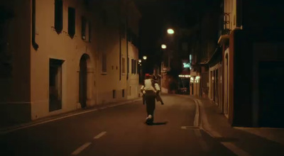 a man walking down a street at night