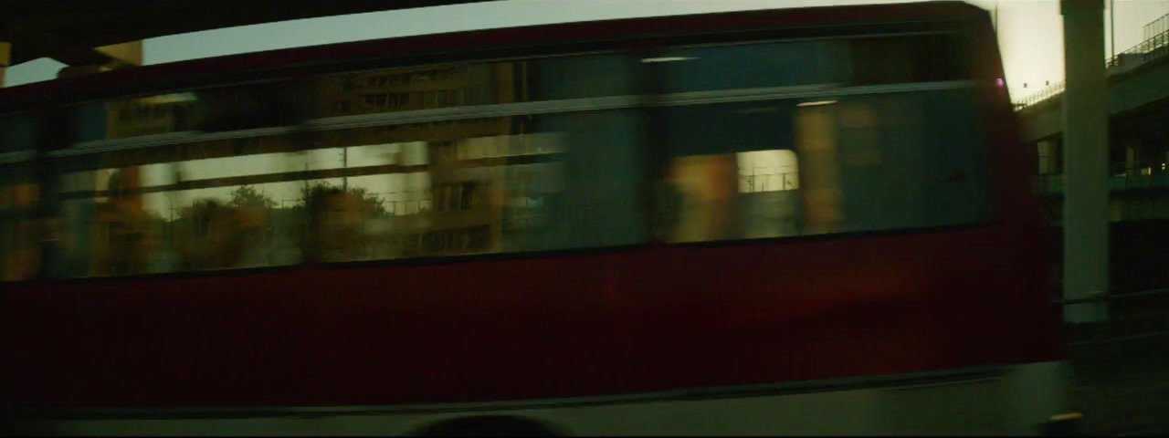 a red double decker bus driving down a street