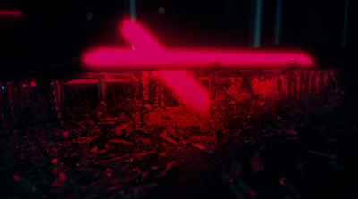 a red neon sign sitting on top of a pile of rubble