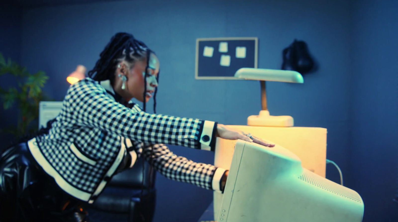 a woman sitting at a desk with a computer monitor