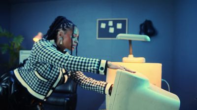 a woman sitting at a desk with a computer monitor