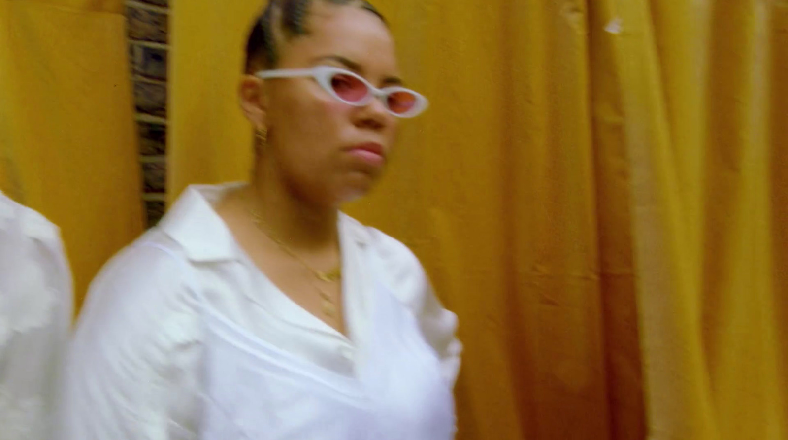 a woman in a white shirt and pink sunglasses