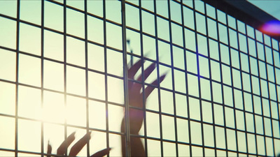 a person reaching up through a wire fence