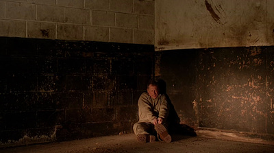 a man sitting on the floor in a dark room