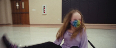 a girl sitting on the floor with a toothbrush in her mouth