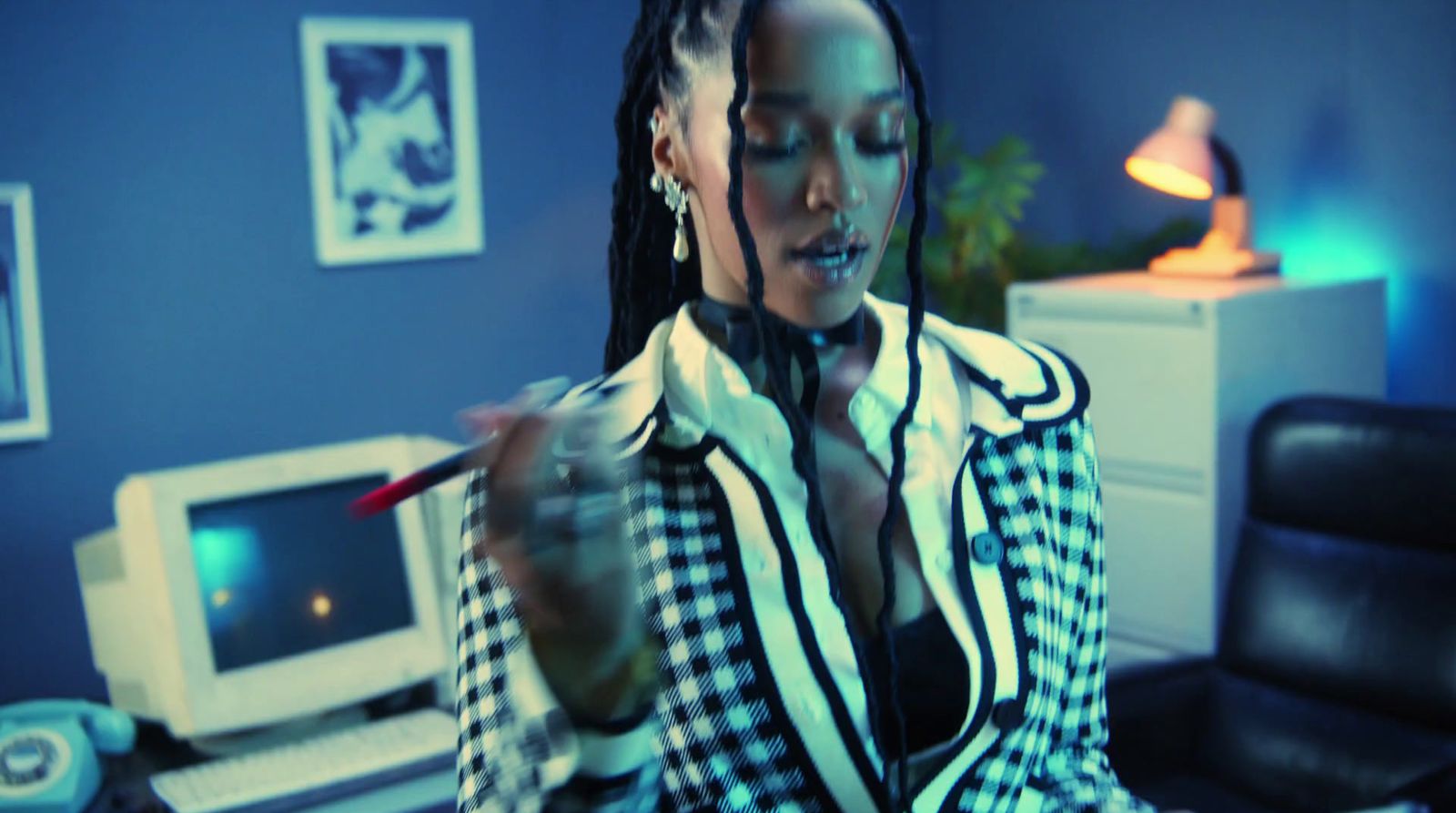 a woman with dreadlocks sitting at a desk