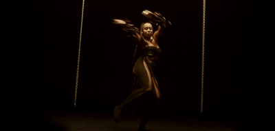 a woman is dancing in the dark with her arms in the air