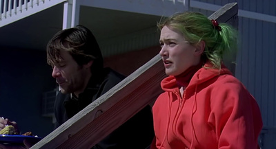 a woman in a red jacket holding a large knife