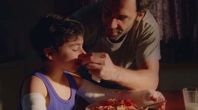 a man feeding a child a piece of food