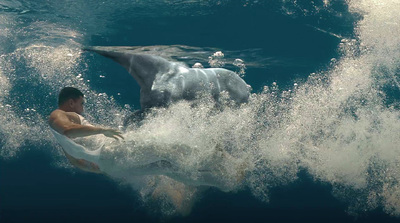 a man riding a wave on top of a surfboard