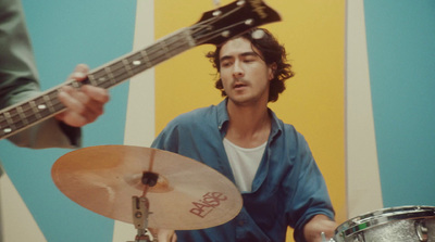 a man with a guitar and a drum in front of him