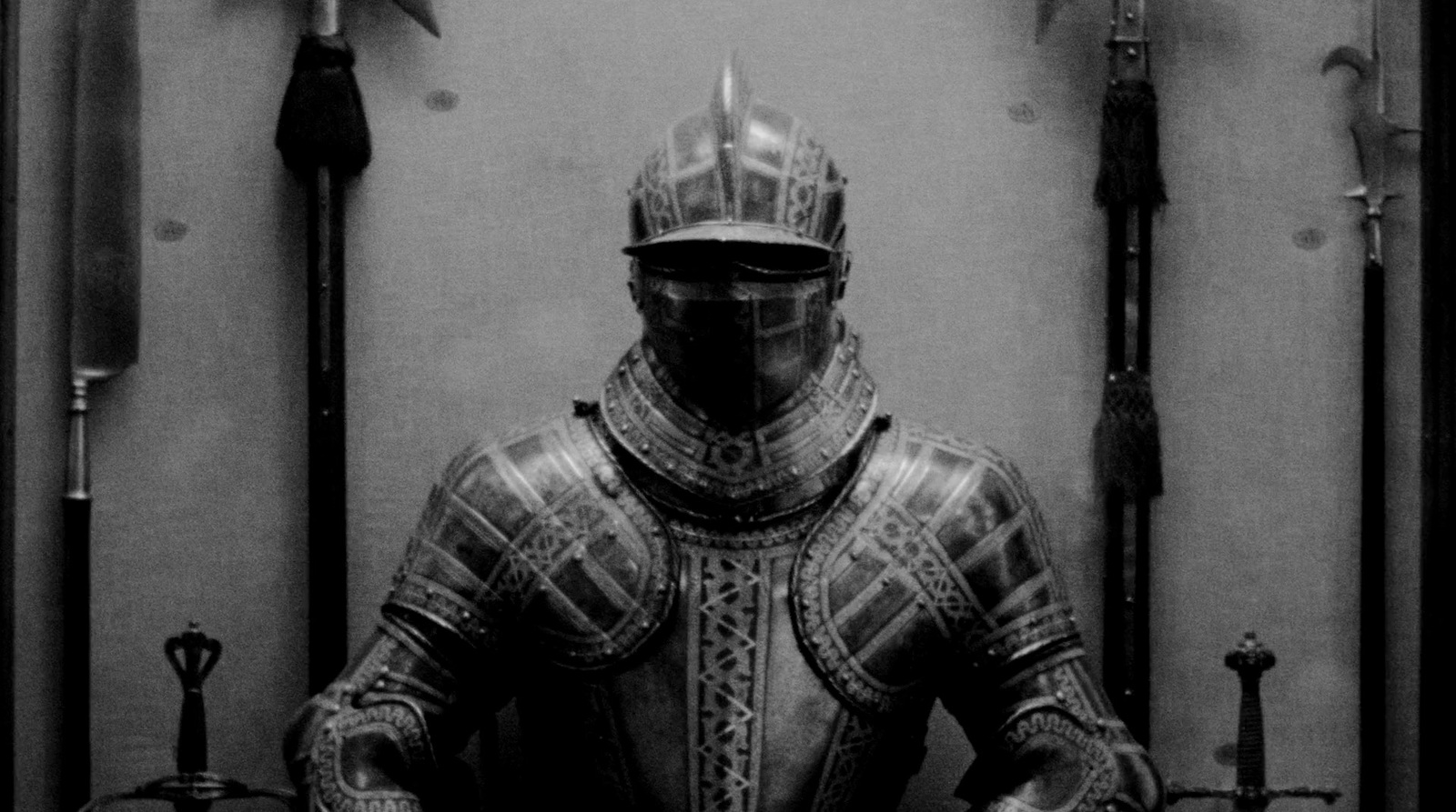 a black and white photo of a knight in armor