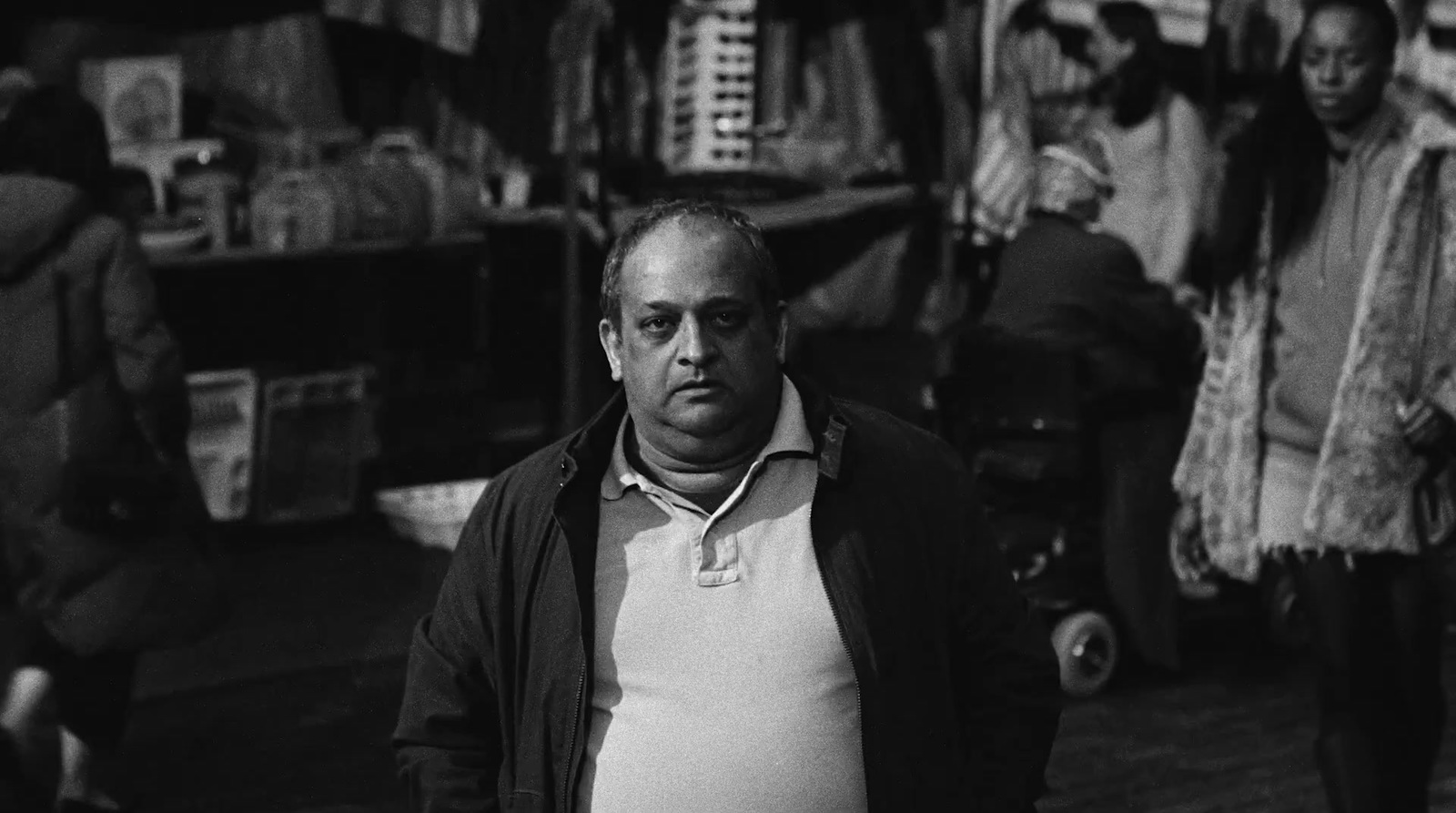 a black and white photo of a man walking down a street