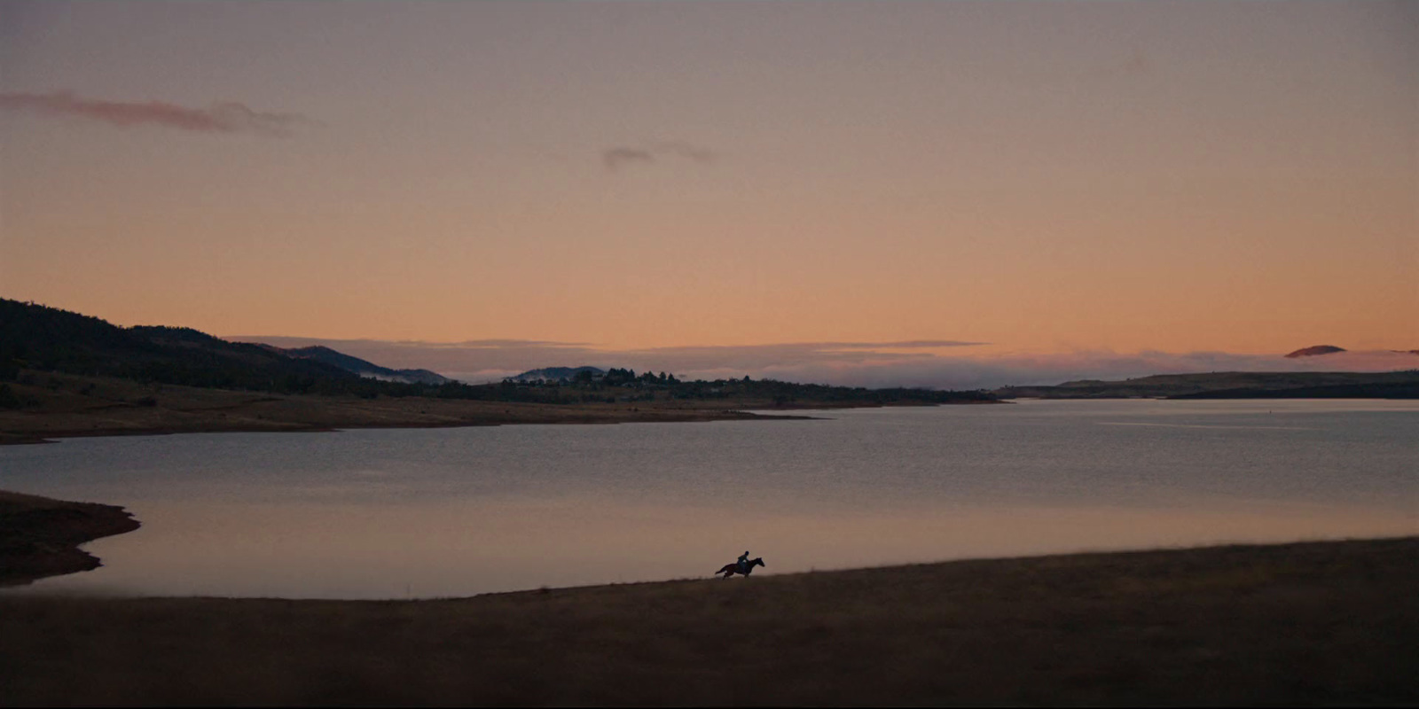 a person riding a horse near a body of water