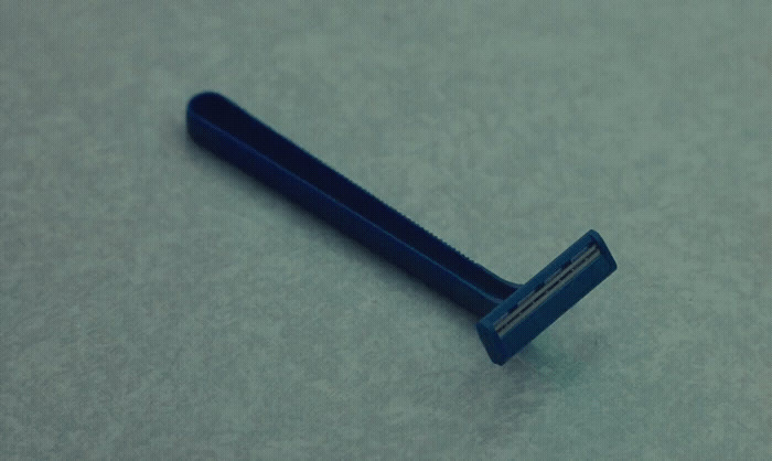 a blue toothbrush laying on a gray surface