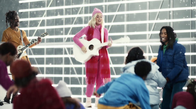 a woman in a pink outfit playing a guitar