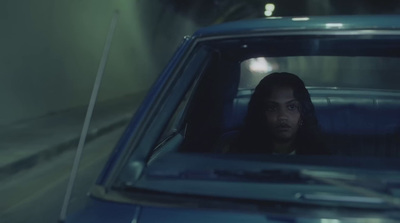 a woman sitting in a car looking out the window