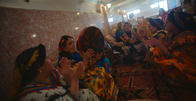 a group of women sitting on the floor clapping